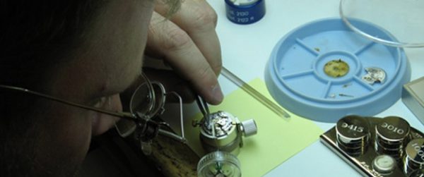 Watch maker repairing a watch